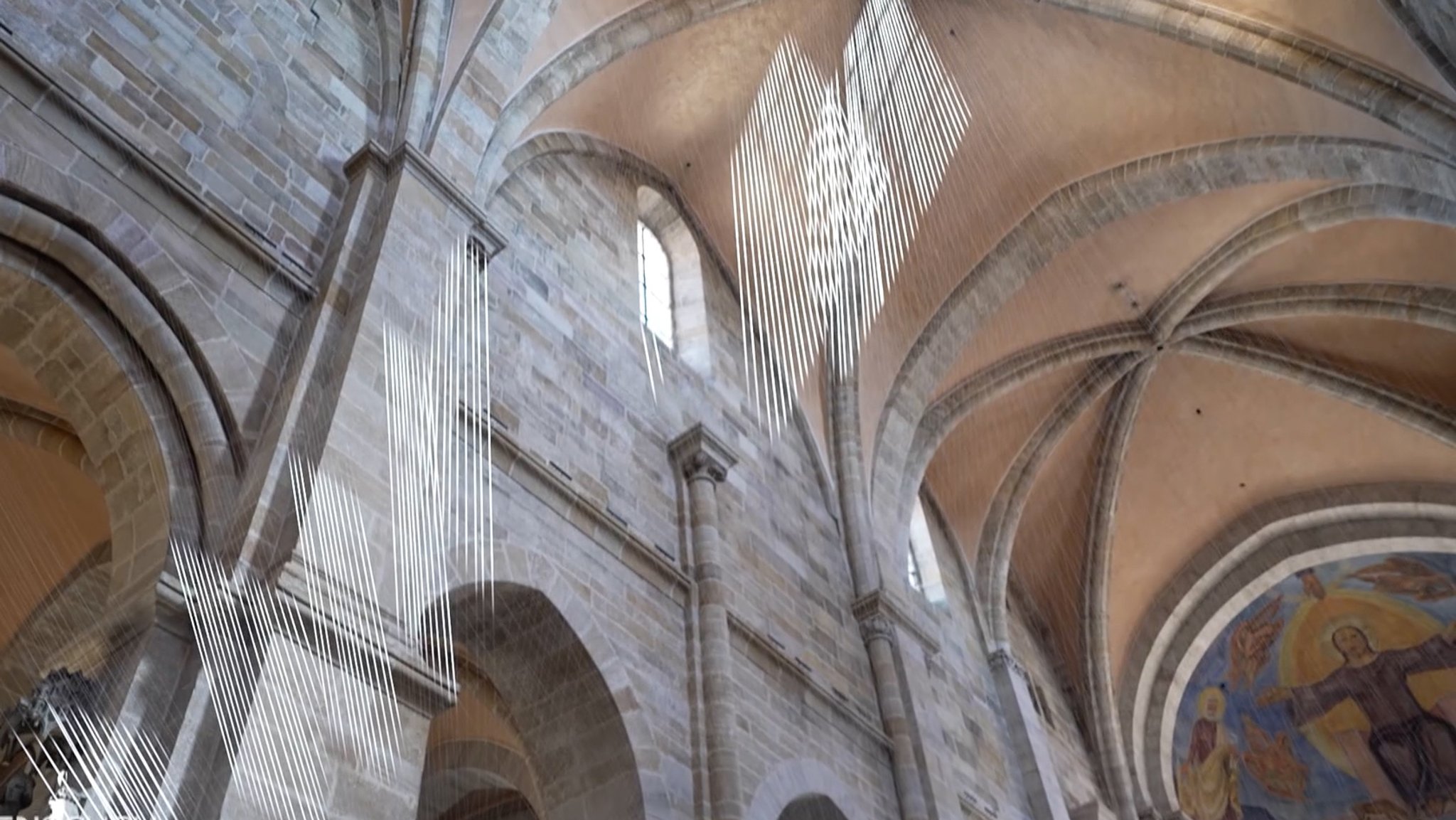 Fäden hängen im Bamberger Dom und reflektieren das hereinfallende Licht.