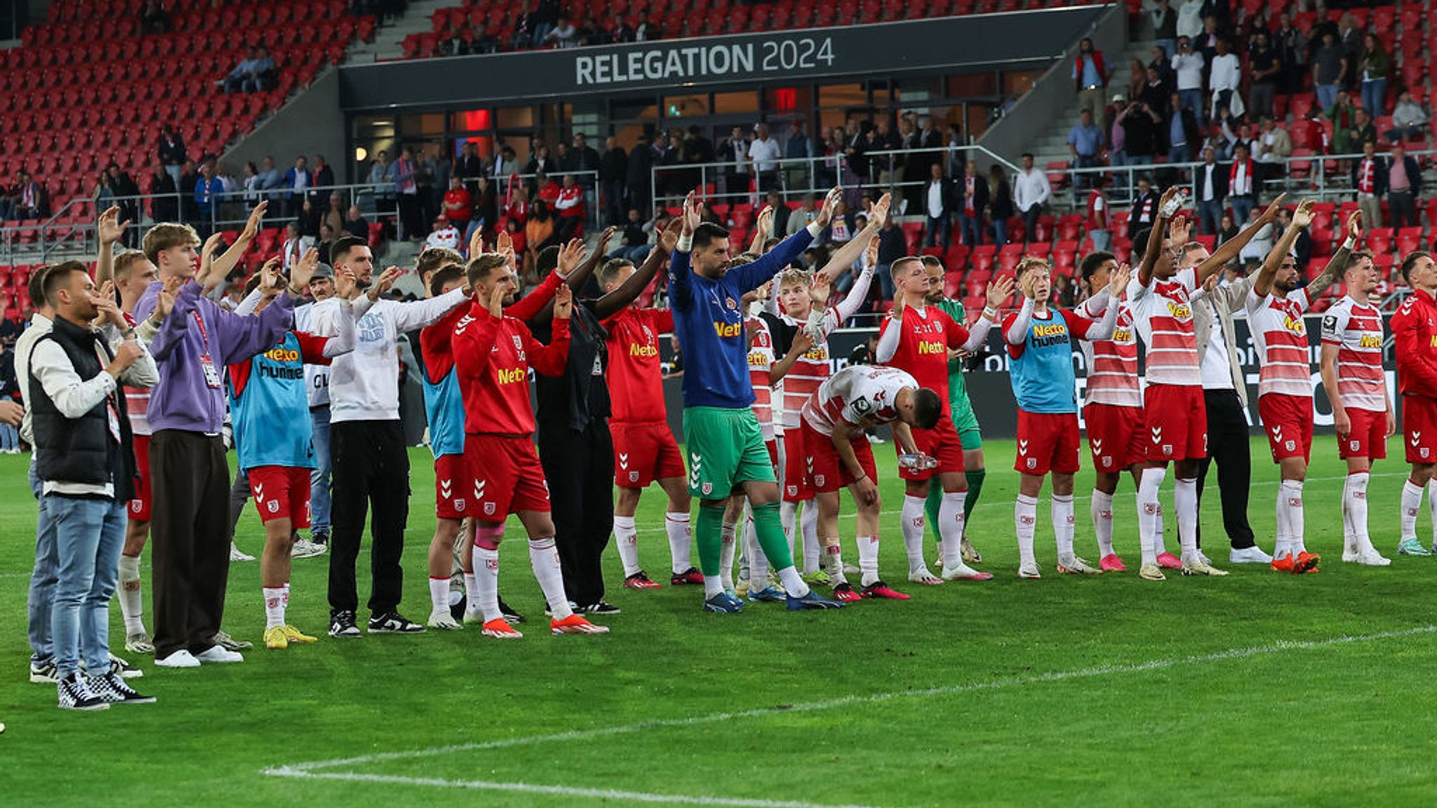 24.05.2024, Bayern, Regensburg: Fußball: 2. Bundesliga - Relegation, Jahn Regensburg - SV Wehen Wiesbaden, Relegation, Hinspiel, Jahnstadion Regensburg. Die Regensburger stehen nach dem Spiel vor ihrer Fankurve. Foto: Daniel Löb/dpa - WICHTIGER HINWEIS: Gemäß den Vorgaben der DFL Deutsche Fußball Liga bzw. des DFB Deutscher Fußball-Bund ist es untersagt, in dem Stadion und/oder vom Spiel angefertigte Fotoaufnahmen in Form von Sequenzbildern und/oder videoähnlichen Fotostrecken zu verwerten bzw. verwerten zu lassen. +++ dpa-Bildfunk +++