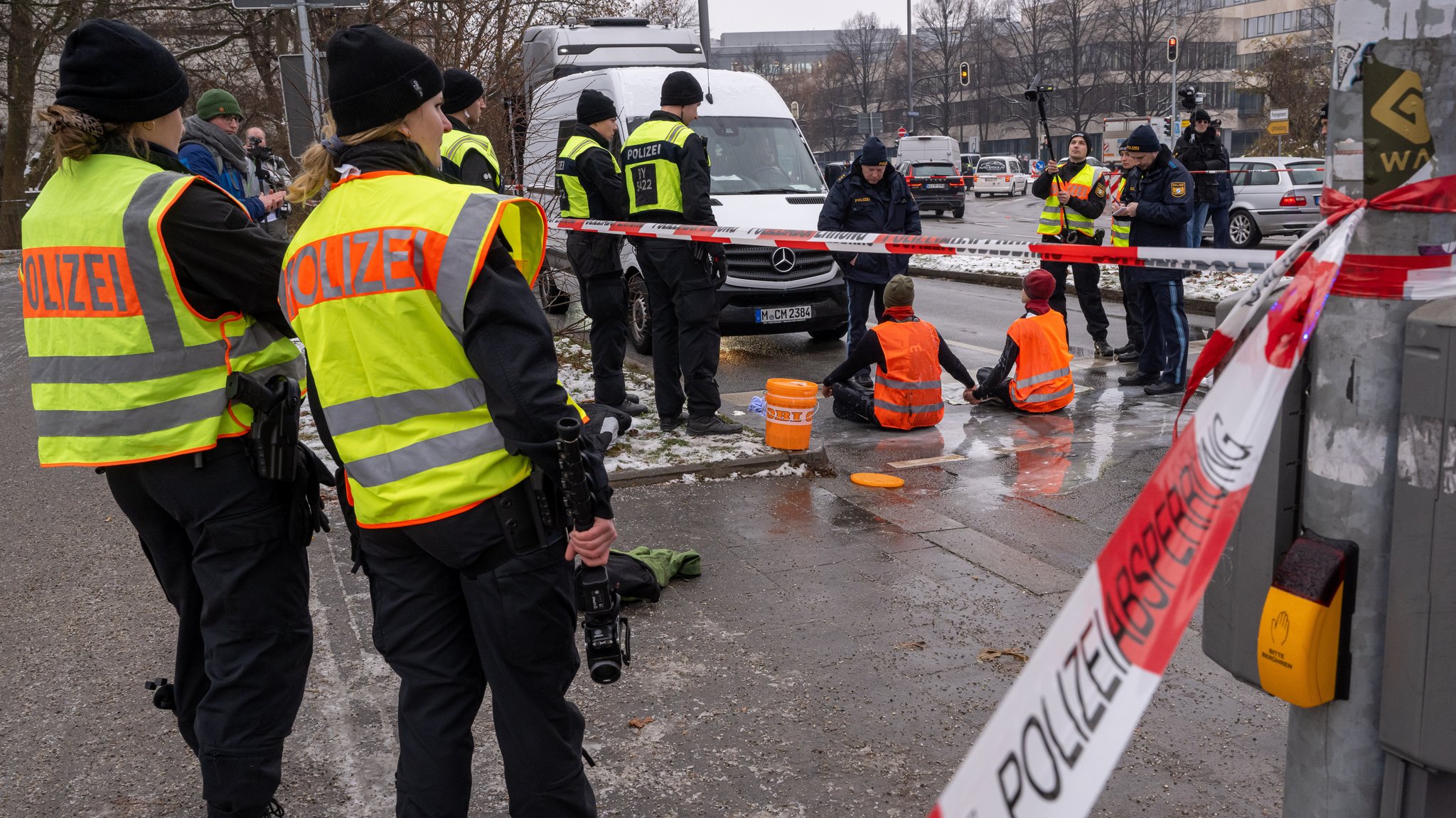 Zwei Klimaaktivisten nehmen an einer Protestaktion der Gruppe "Letzte Generation" teil, indem sie versuchen sich auf einer Straße festzukleben. 