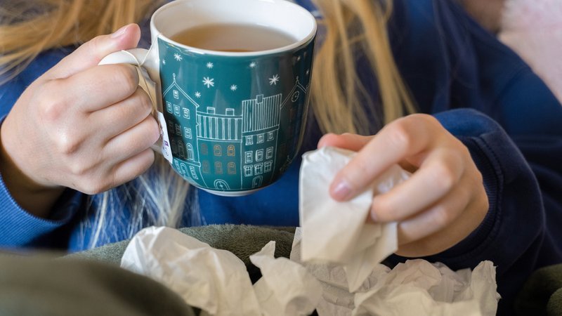 (Symbolbild) Eine Frau hält eine Teetasse und ein Taschentuch in der Hand. | Bild: picture alliance/dpa | Alicia Windzio (Symbolbild) Eine Frau hält eine Teetasse und ein Taschentuch in der Hand.