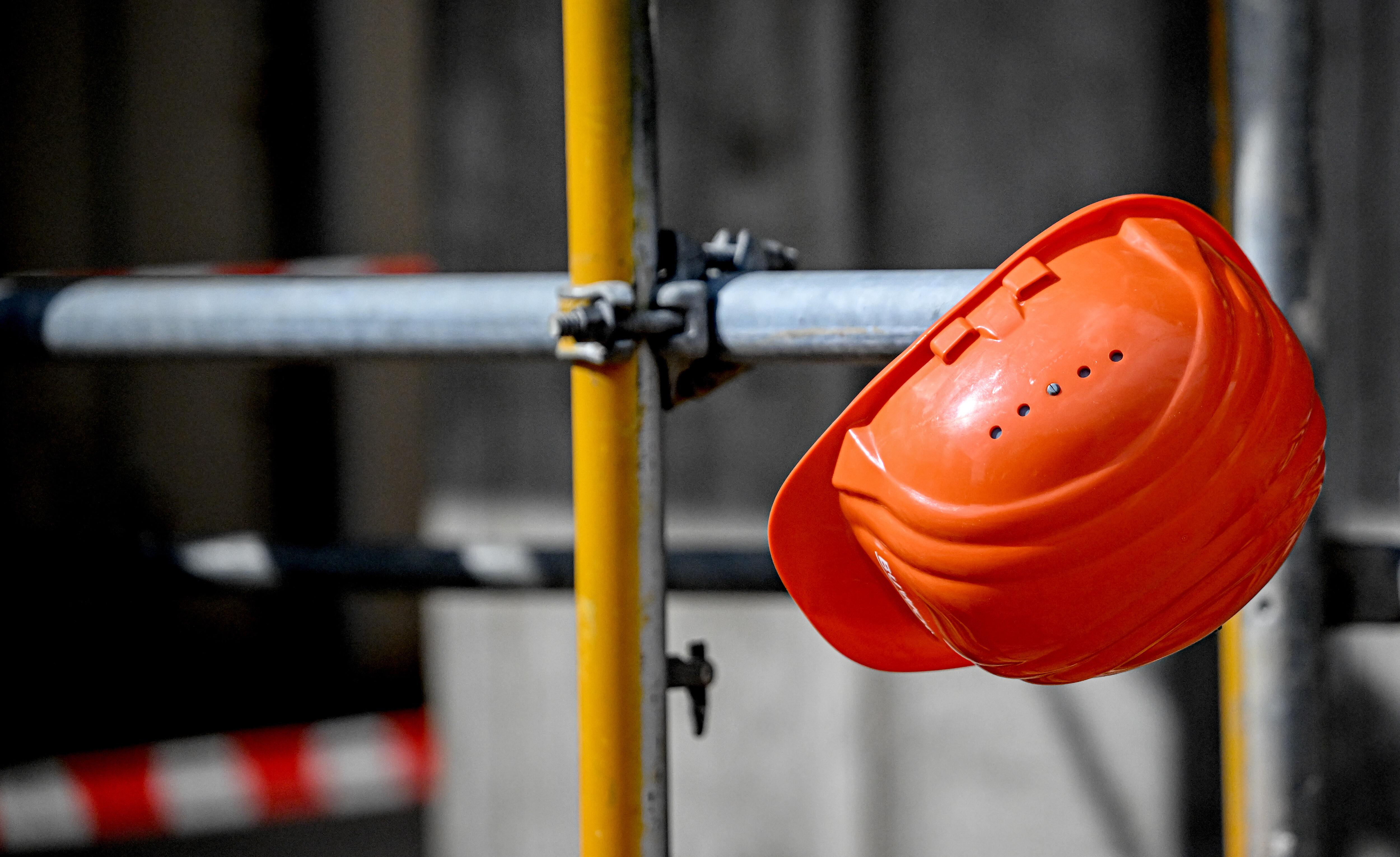 Ein Bauhelm hängt bei einer Baustelle