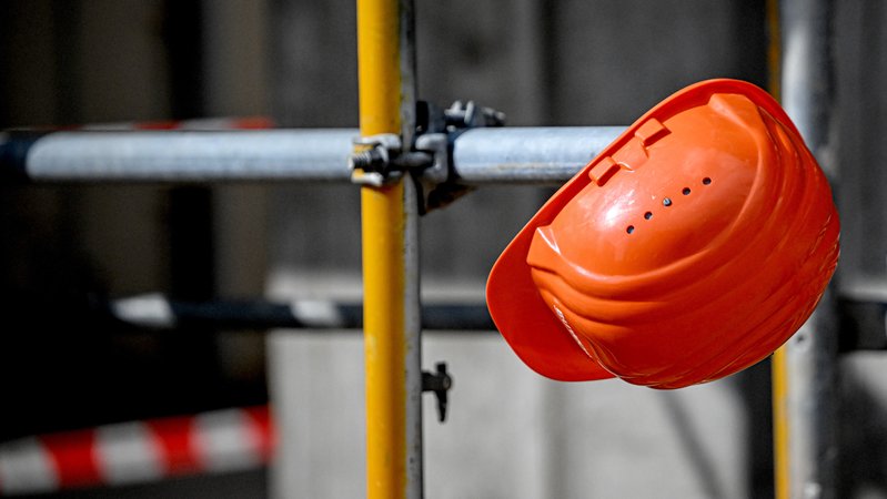 Ein Bauhelm hängt bei einer Baustelle | Bild: picture alliance/dpa | Britta Pedersen Ein Bauhelm hängt bei einer Baustelle