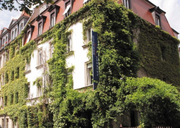 Ein begrüntes Haus mit einem Schild "Gostner Hoftheater".