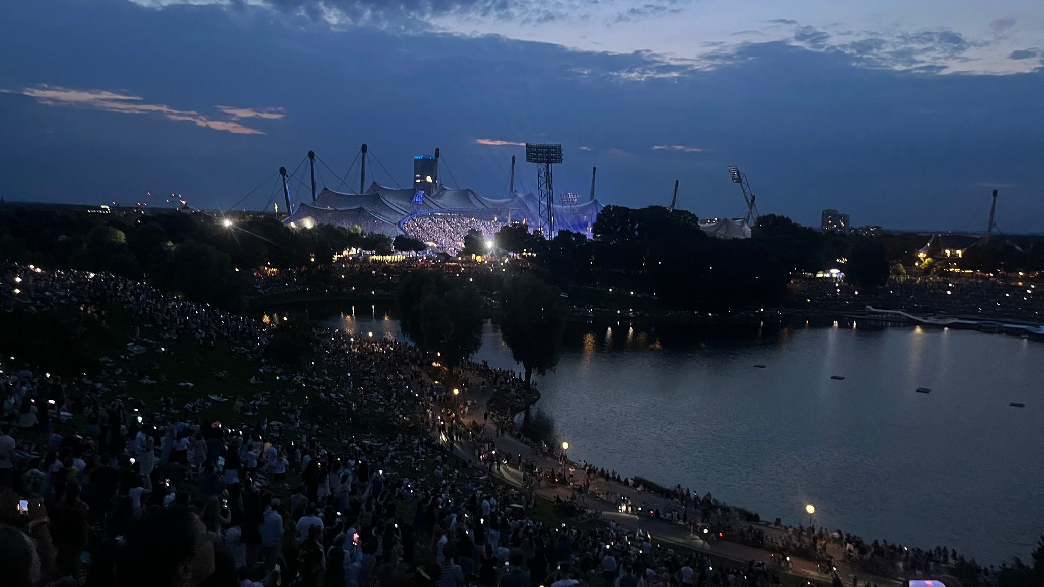 Es wird dunkel über dem Olympiastadion – Tausende "Swifties" verfolgen das Taylor-Swift-Konzert vom Olympiaberg aus