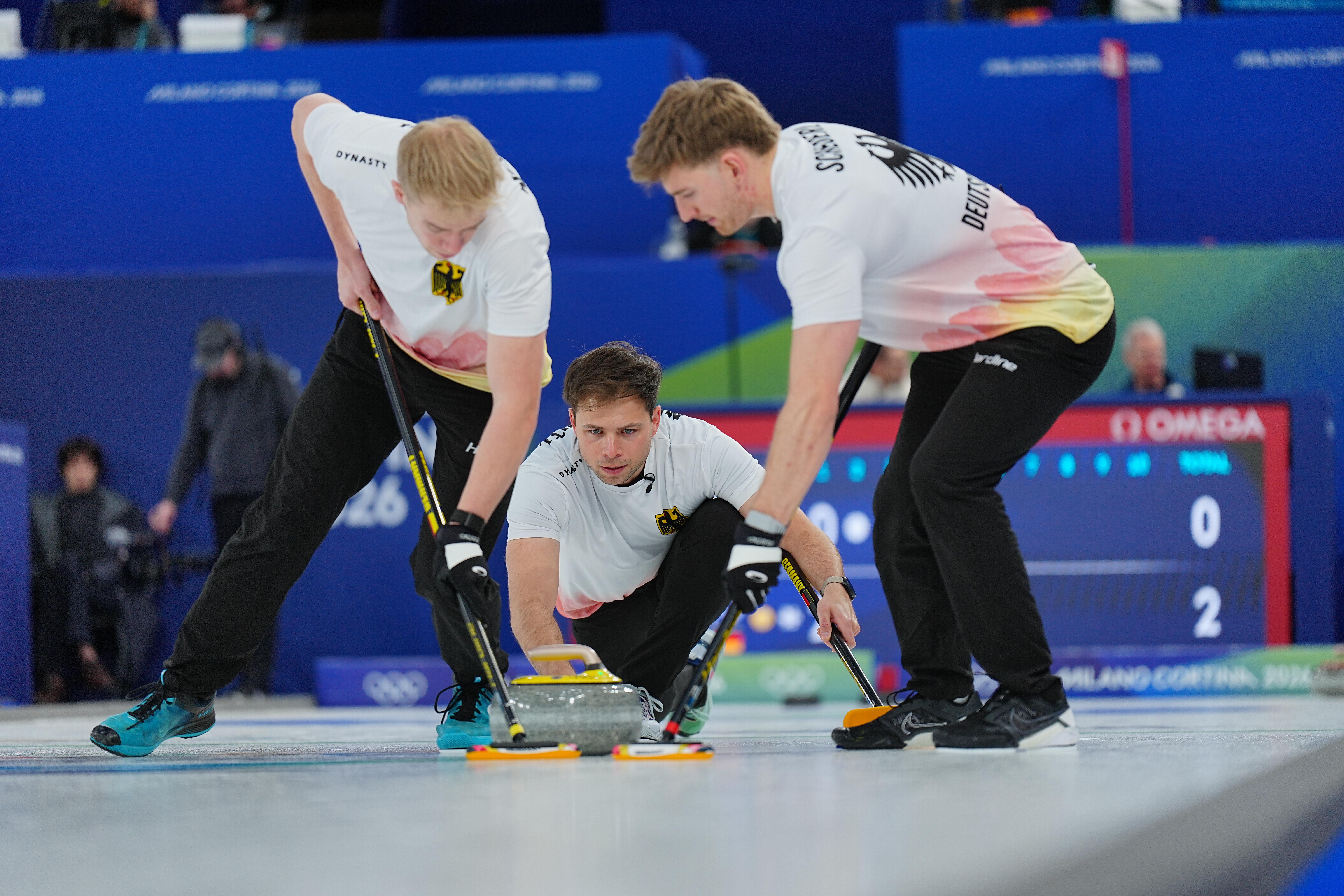 Marc Muskatewitz (M, Deutschland) spielt den Stein während Felix Messenzehl (l) und Johannes Scheuerl wischen.