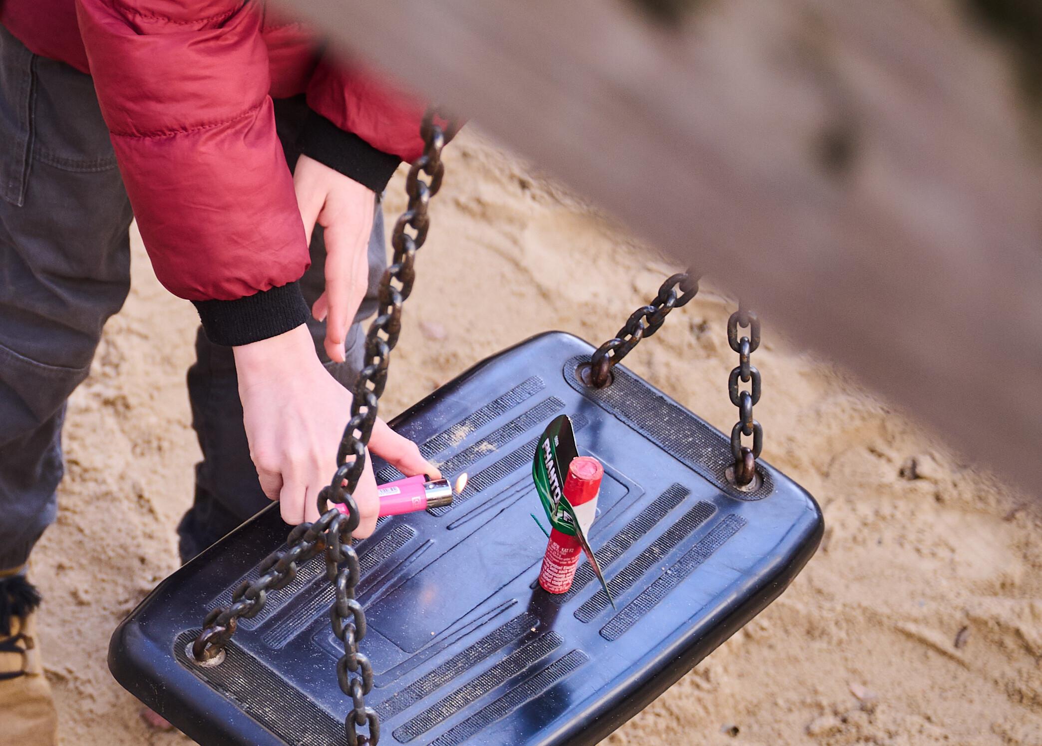(Symbolbild) Ein Kind zündet auf einem Spielplatz Silvesterböller an. 
