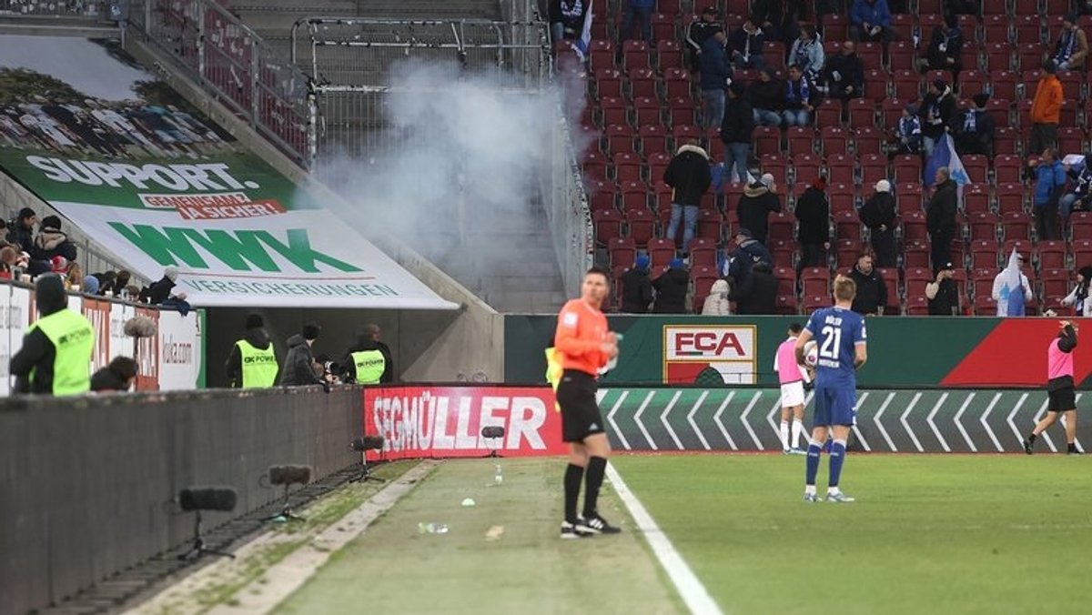 Eine Rauchwolke am Gästeblock nach einer lauten Explosion während des Spiels FC Augsburg gegen 1890 Hoffenheim