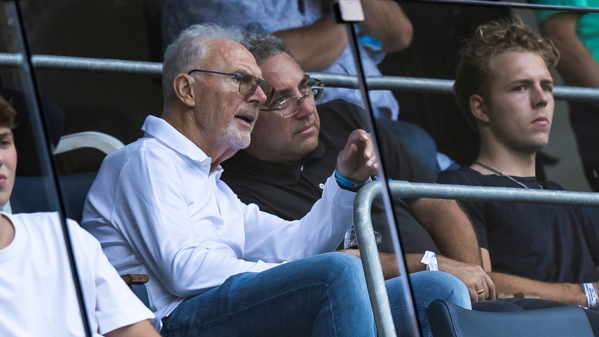 Franz Beckenbauer sitzt auf der Tribüne.