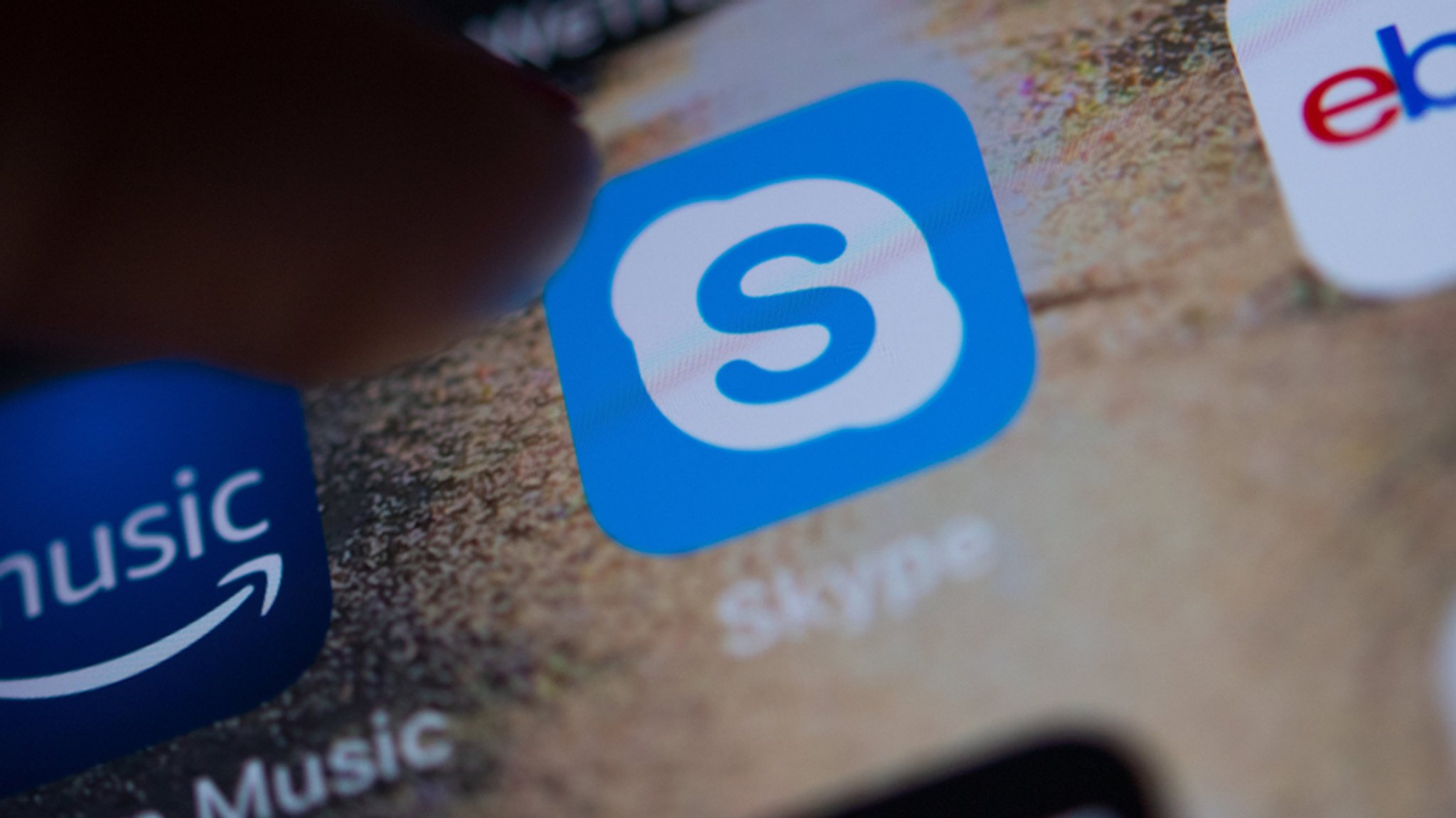 Das Logo der App des Messengers Skype ist auf dem Display eines Smartphones zu sehen.