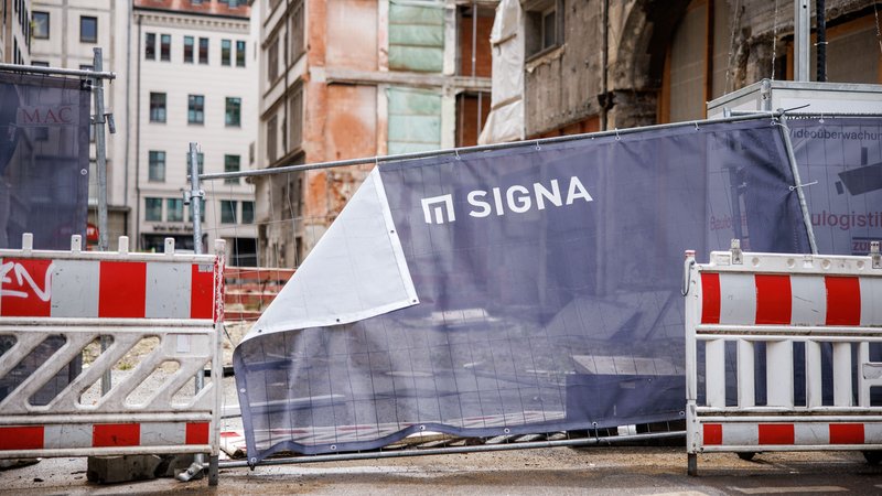 Ein schief hängender Bauzaun mit dem Signa-Logo verdeckt die Sicht auf eine Baulücke am Münchner Hauptbahnhof. | Bild: picture alliance / dpa | Matthias Balk Ein schief hängender Bauzaun mit dem Signa-Logo verdeckt die Sicht auf eine Baulücke am Münchner Hauptbahnhof.