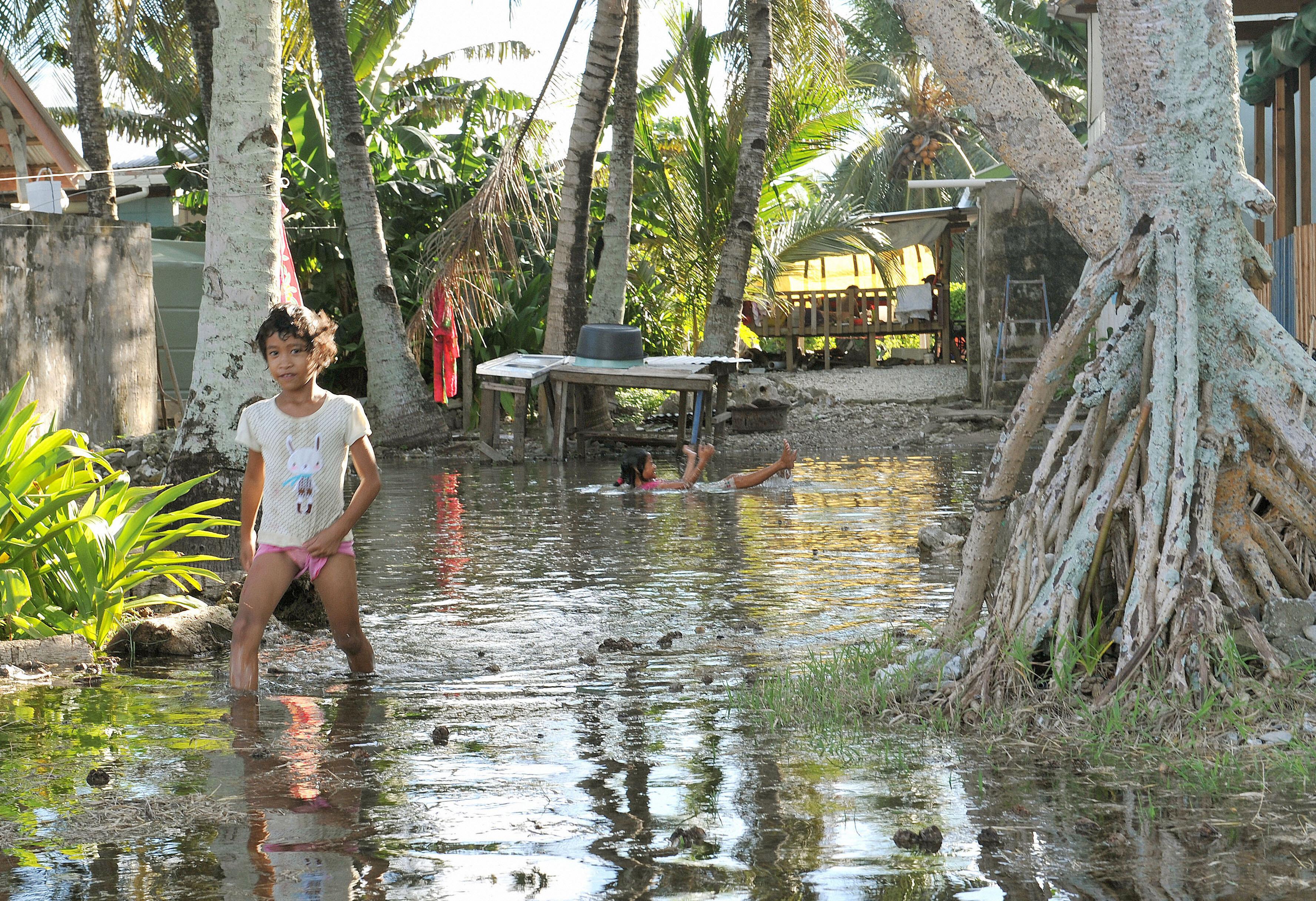 Mädchen watet durch überschwemmten Teil von Funafuti, der Hauptstadt von Tuvalu.