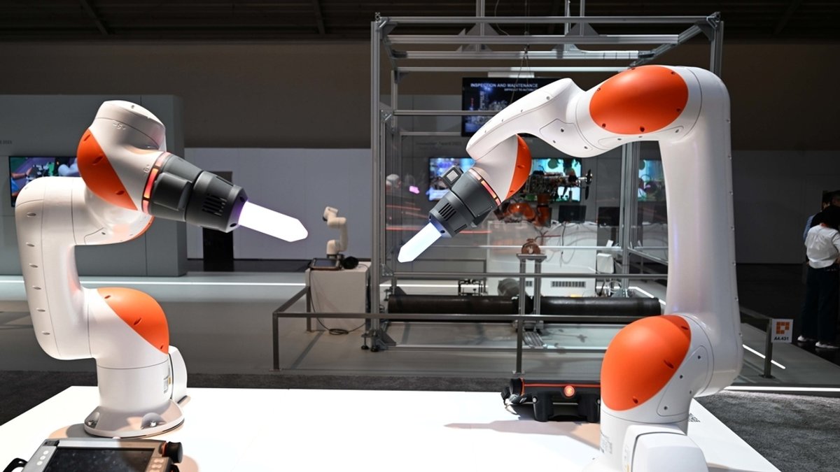 Roboterarme der Firma KUKA sind auf der Automatica 2023 in einer Halle der Messe München zu sehen.
