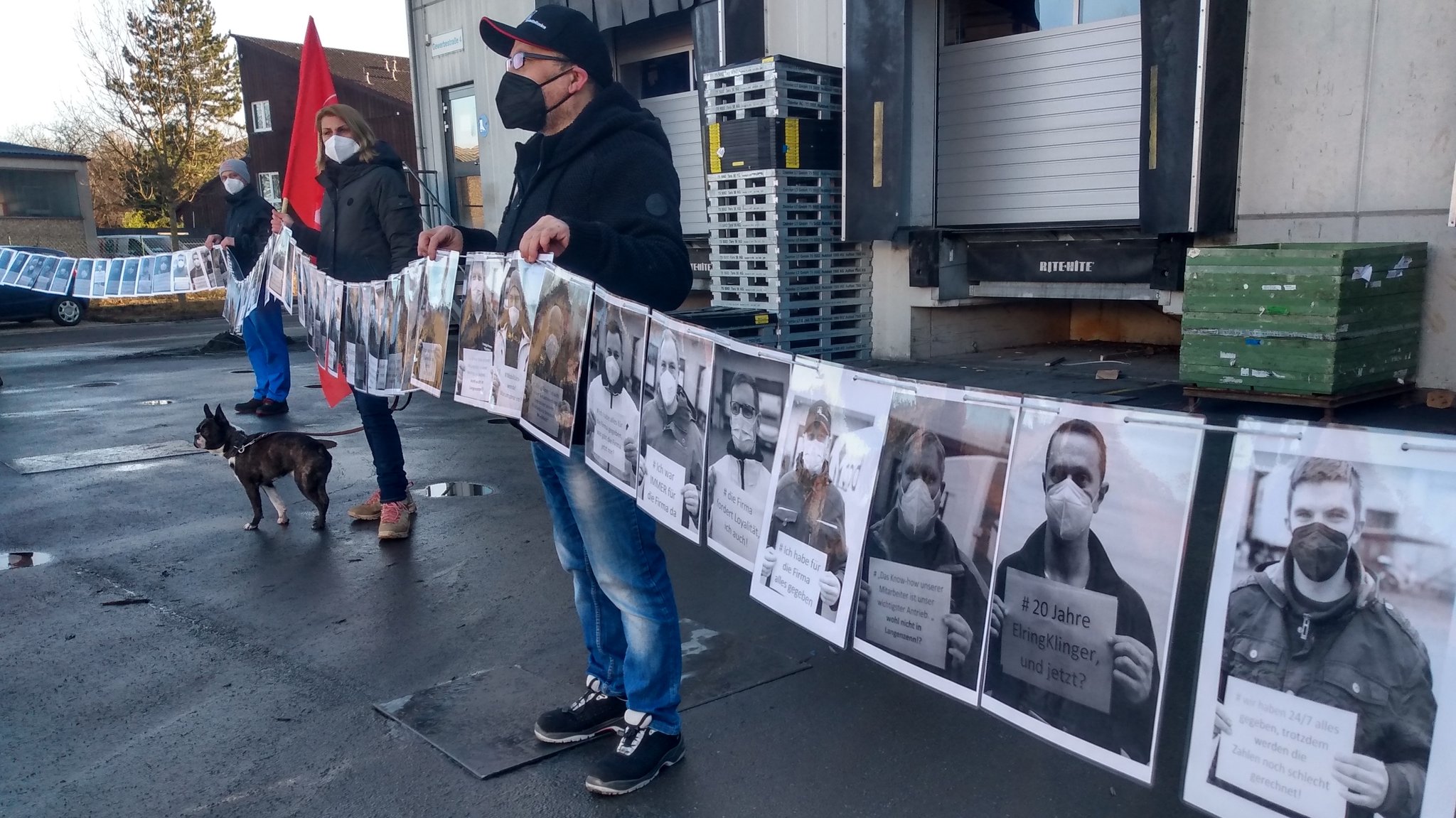 Vor dem Werkstor von Elringklinger halten Beschäftigte eine Kette mit Portraits.