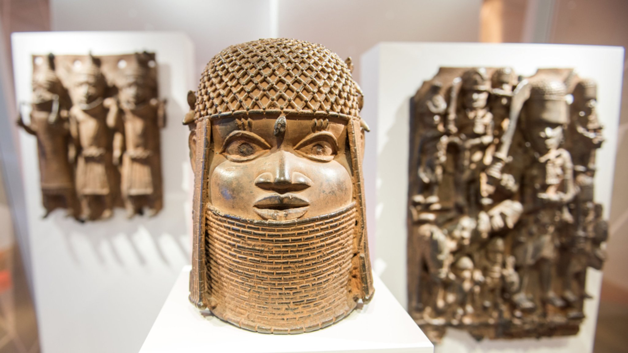 Hamburg: Drei Raubkunst-Bronzen aus dem Land Benin in Westafrika sind im Museum für Kunst und Gewerbe (MKG) in einer Vitrine ausgestellt.