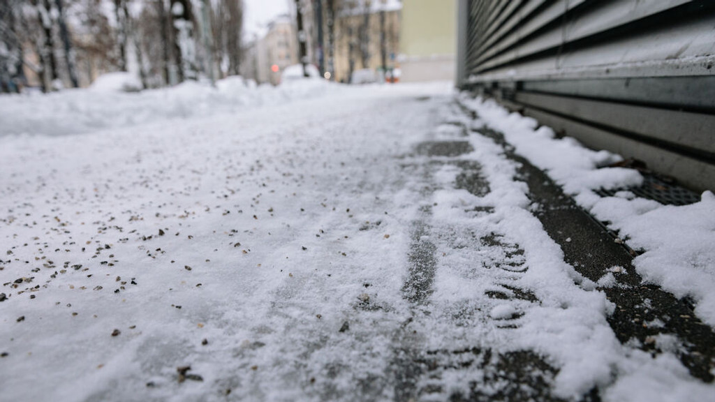 Streusplit auf einem schneebedeckten Fußweg.