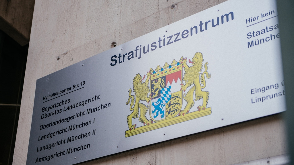 Nahaufnahme eines Schilds mit der Aufschrift "Strafjustizzentrum" und einer Auflistung der dazugehörenden Gerichte sowie dem bayerischen Wappen.