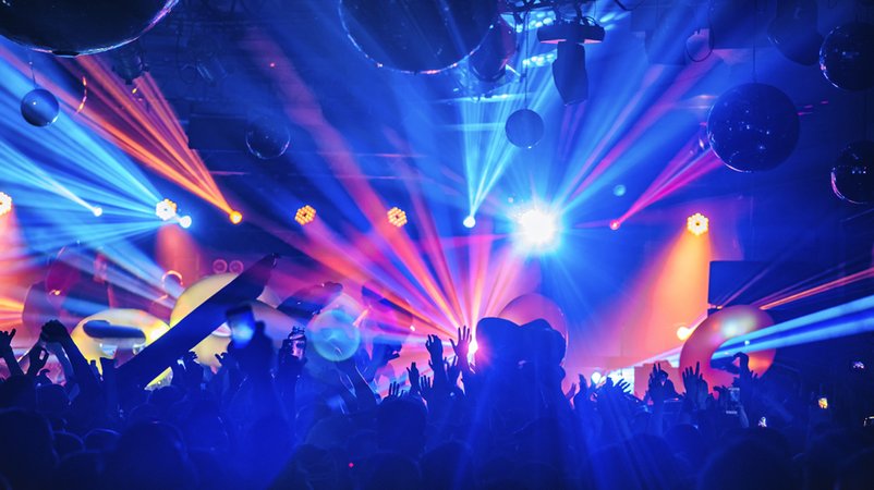 Menschen feiern ausgelassen in einem Club. | Bild: stock.adobe.com/glazok Menschen feiern ausgelassen in einem Club.