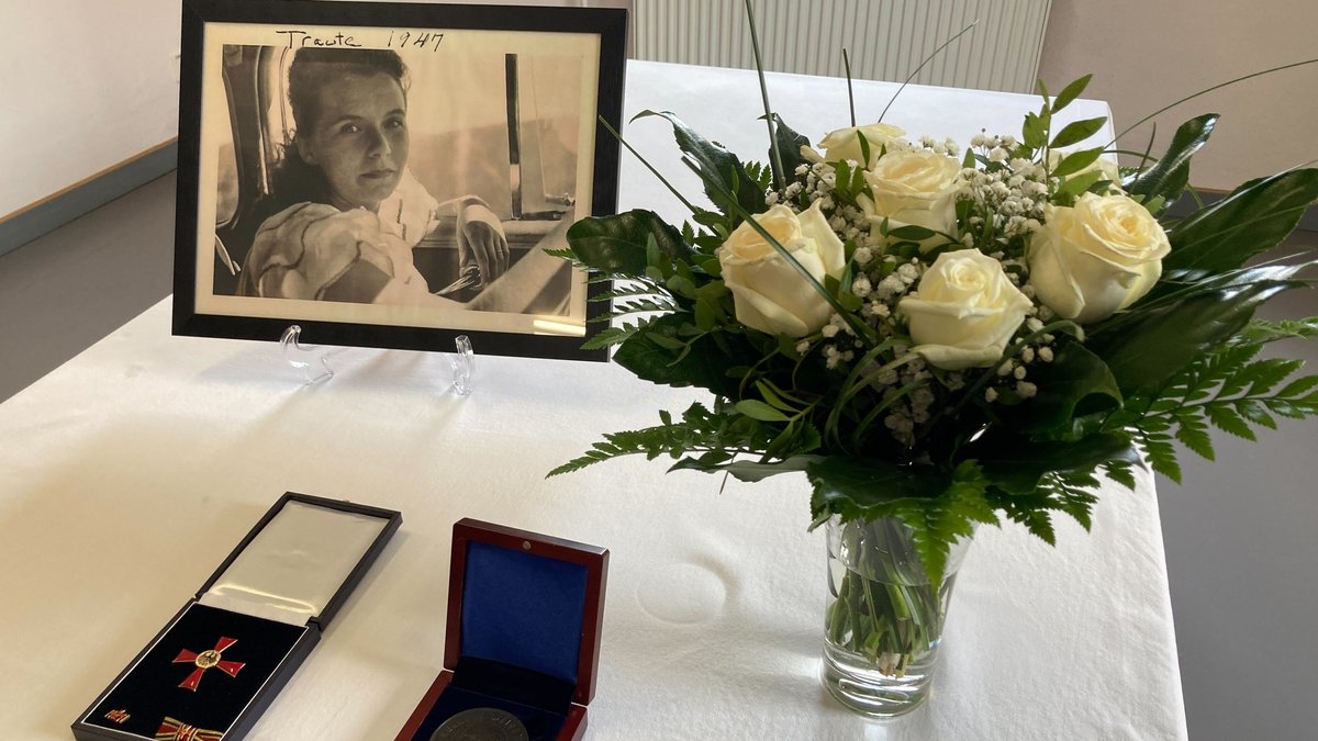 Ehrung für Traute Lafrenz: Ein Foto von ihr in jungen Jahren, ein Blumenstrauß, das ihr verliehene Bundesverdienstkreuz und die Herbert Weichmann-Medaille