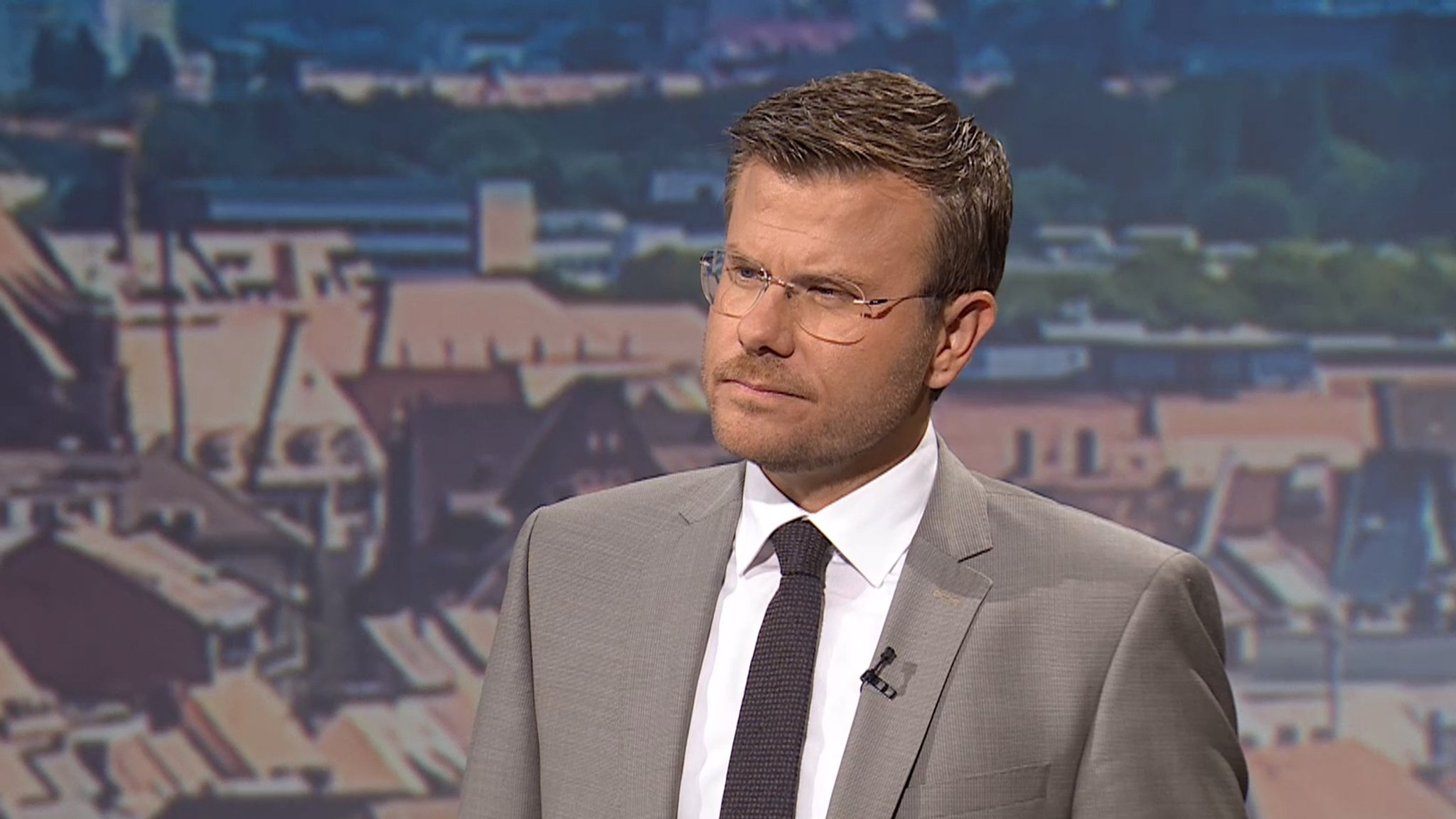 Nürnbergs Oberbürgermeister Marcus König im Fernseh-Studio vor einem Nürnberg-Bild.