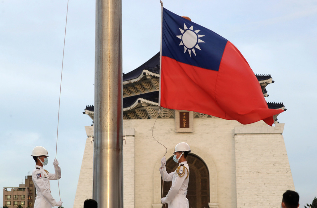 Zwei Soldaten senken die Nationalflagge während der täglichen Flaggenzeremonie auf dem Freiheitsplatz der Chiang Kai-shek Memorial Hall.