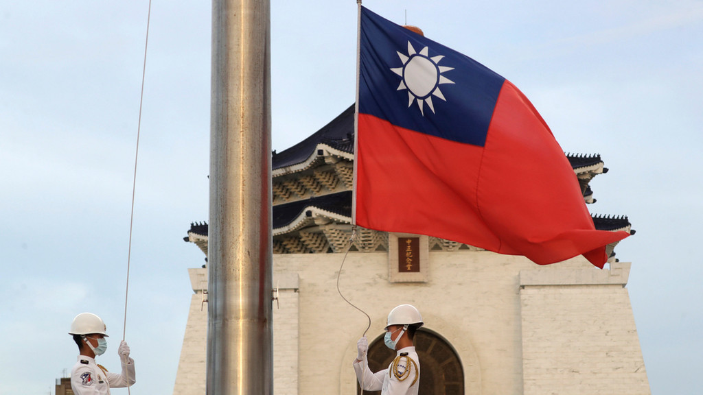 Zwei Soldaten senken die Nationalflagge während der täglichen Flaggenzeremonie auf dem Freiheitsplatz der Chiang Kai-shek Memorial Hall.