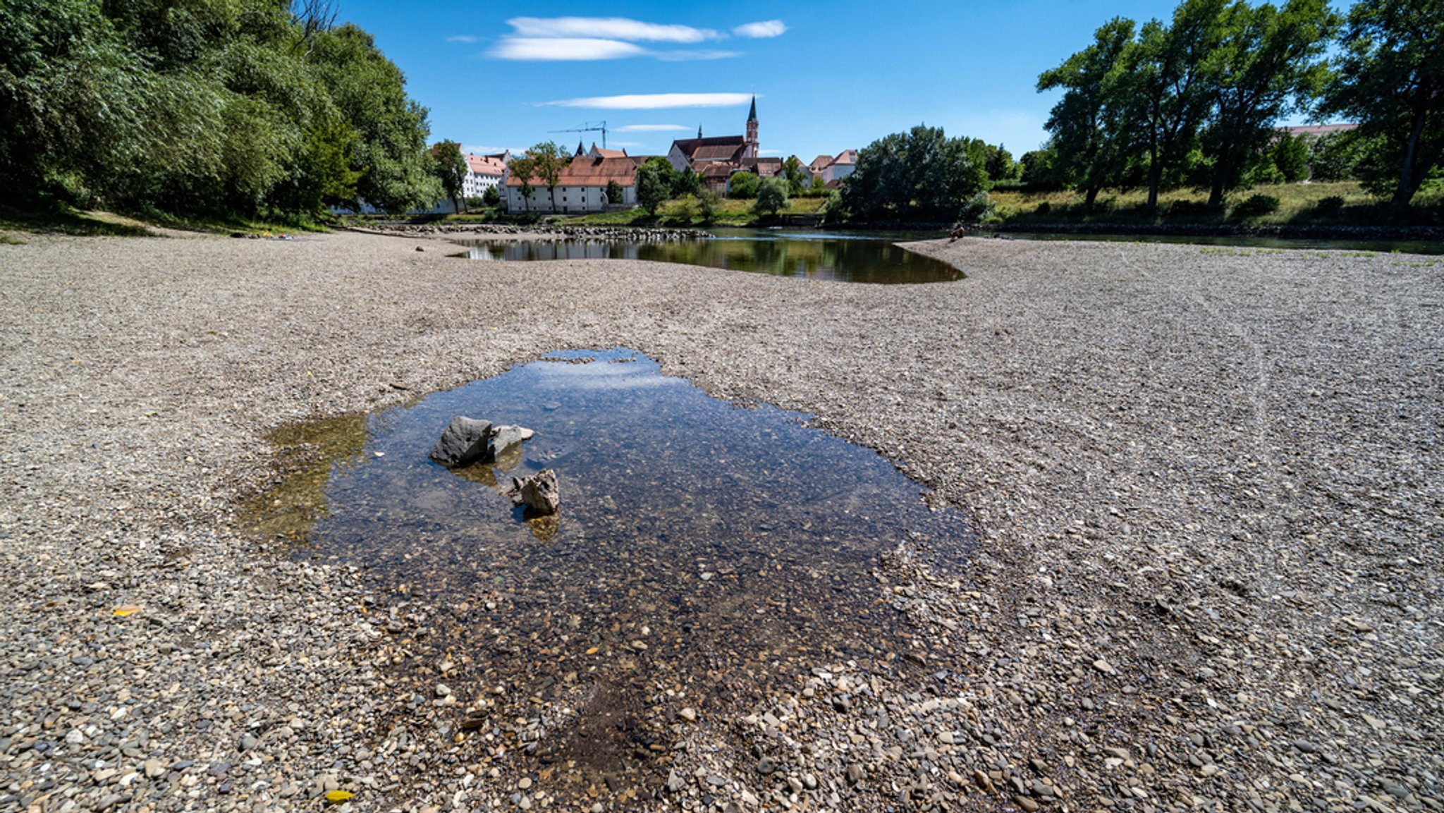 13.07.2022, Bayern, Straubing: Kies liegt am Ufer der Niedrigwasser führenden Donau.