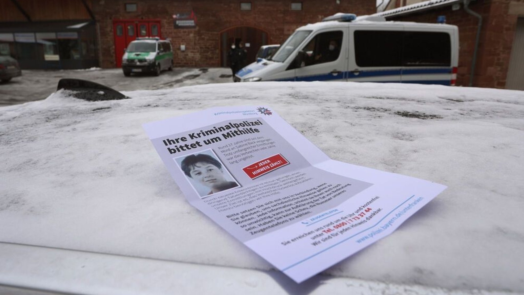 Ein Flugblatt, auf dem die Bevölkerung um Hinweise auf einen Mordfall in Karlstadt gebeten wird, liegt auf einem Autodach.