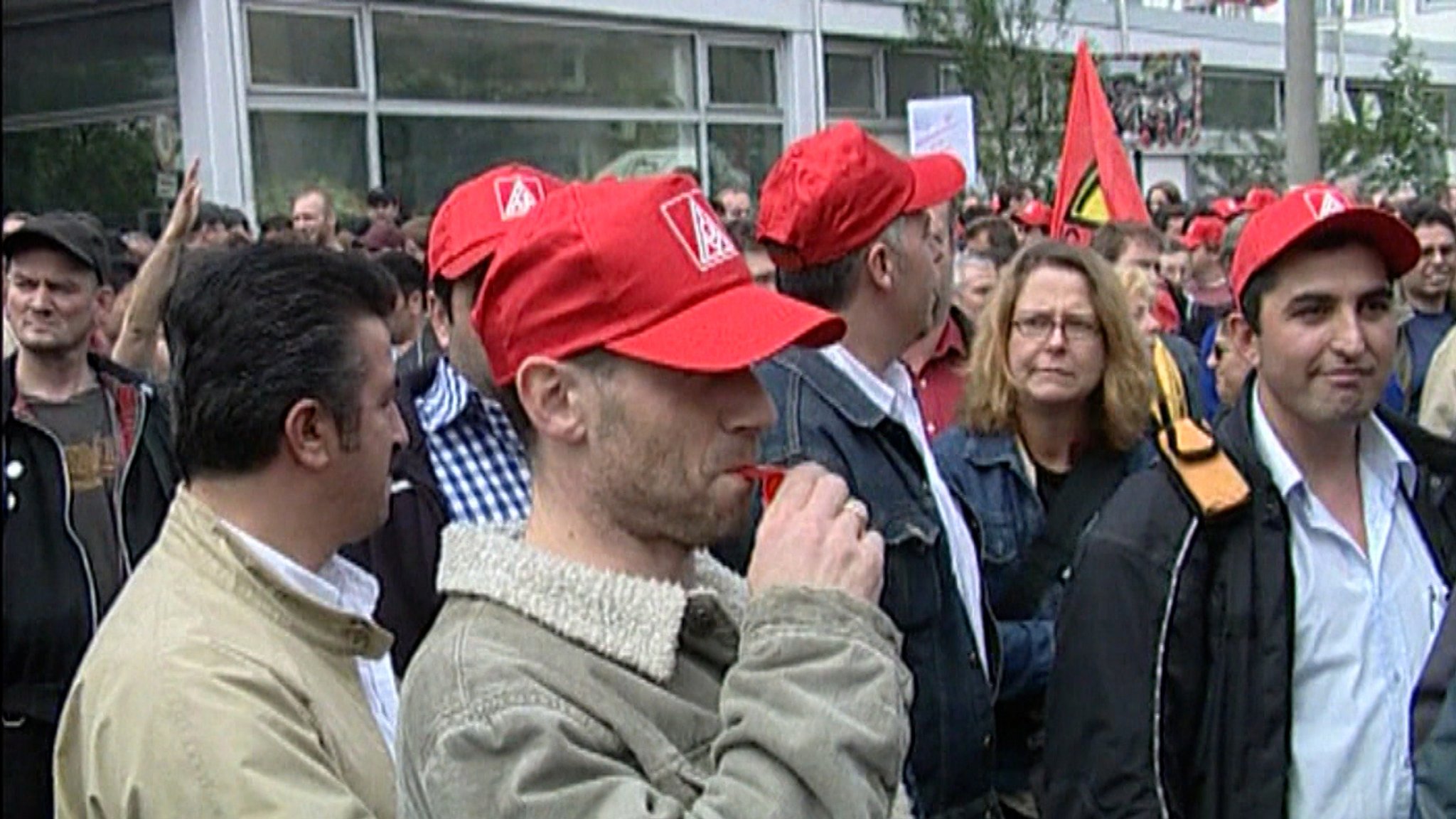 Beschäftigte des Nürnberger AEG-Stammwerks während einer Protestaktion im Jahr 2006: Mit roten IG-Metall-Kappen demonstrieren sie gegen die geplante Werksschließung – Beginn der längsten Werksbesetzung der deutschen Industriegeschichte.