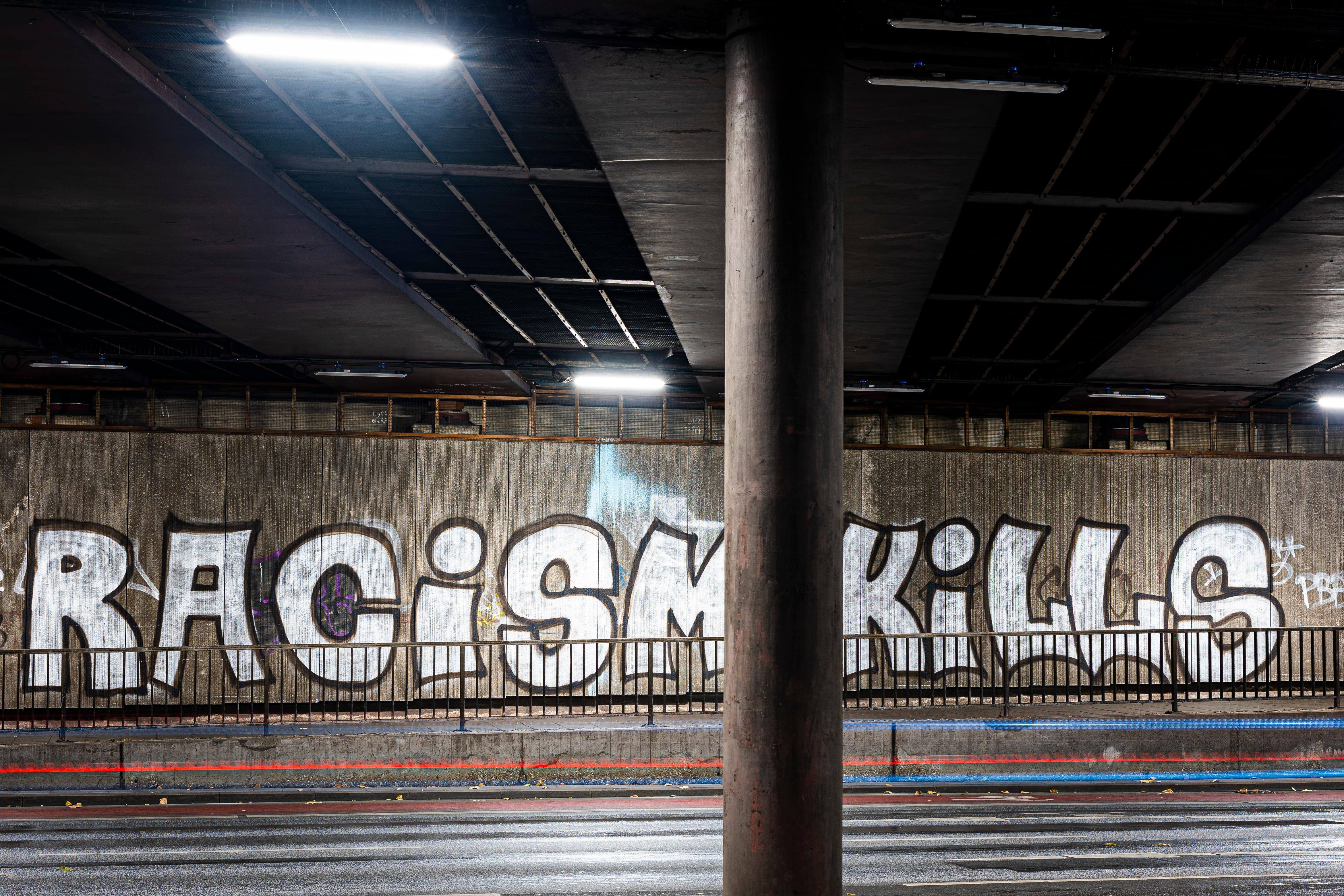 Graffiti mit der Aufschrift "racism kills" in einer Unterführung
