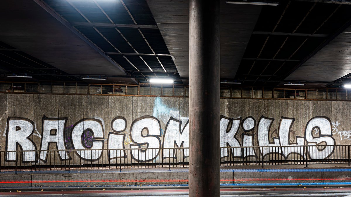 Graffiti mit der Aufschrift "racism kills" in einer Unterführung