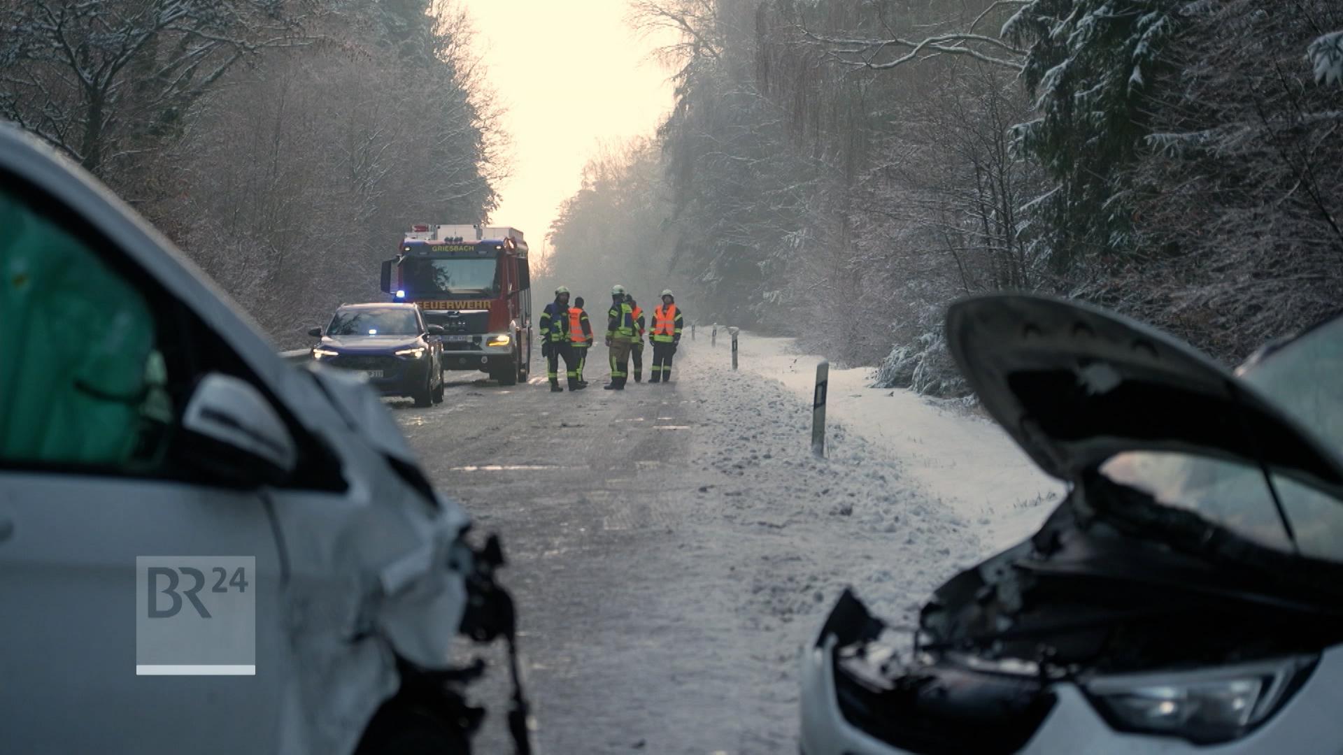 Feuerwehr steht bei einem Verkehrsunfall auf schneeglatter Fahrbahn