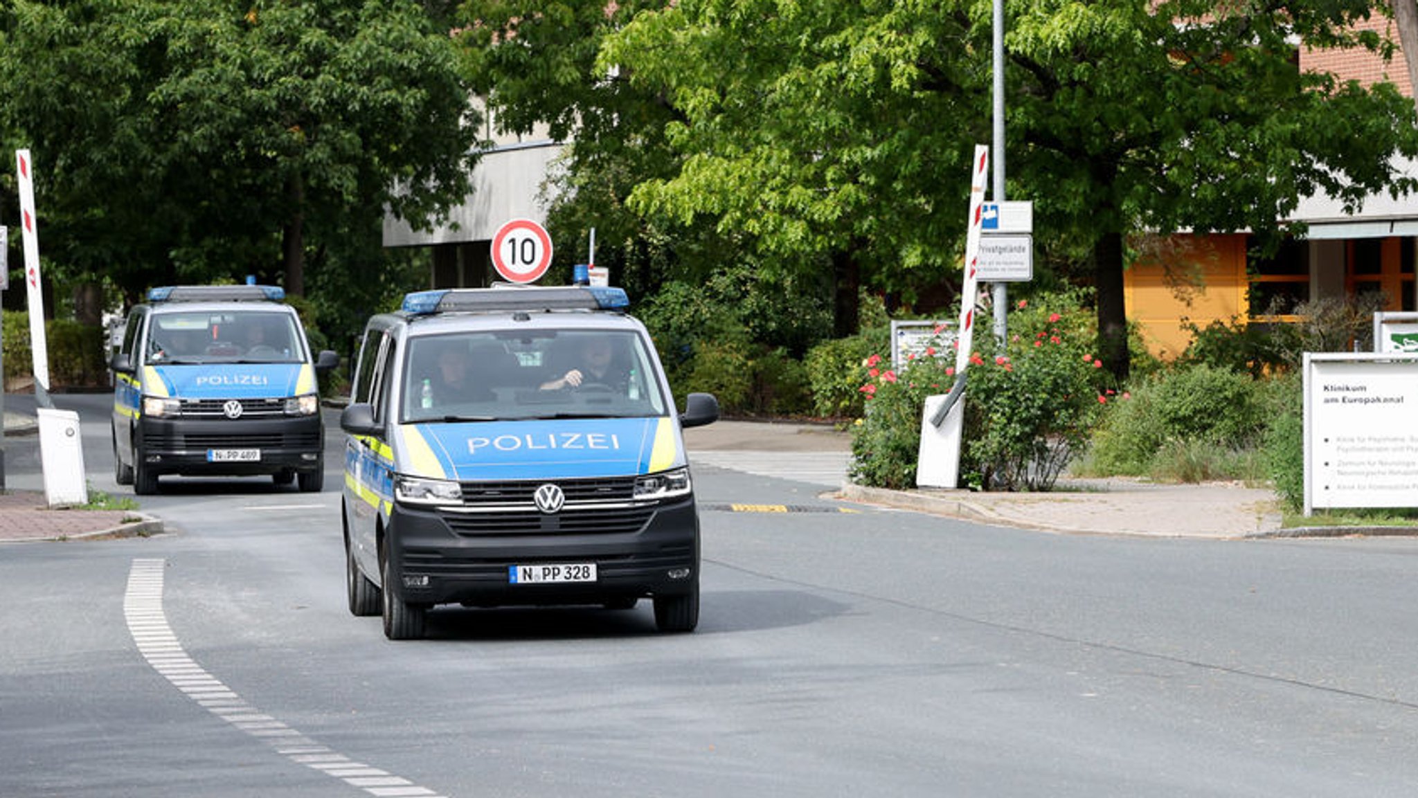 Zwei Fahrzeuge der Polizei verlassen das Gelände von dem Klinikum am Europakanal.
