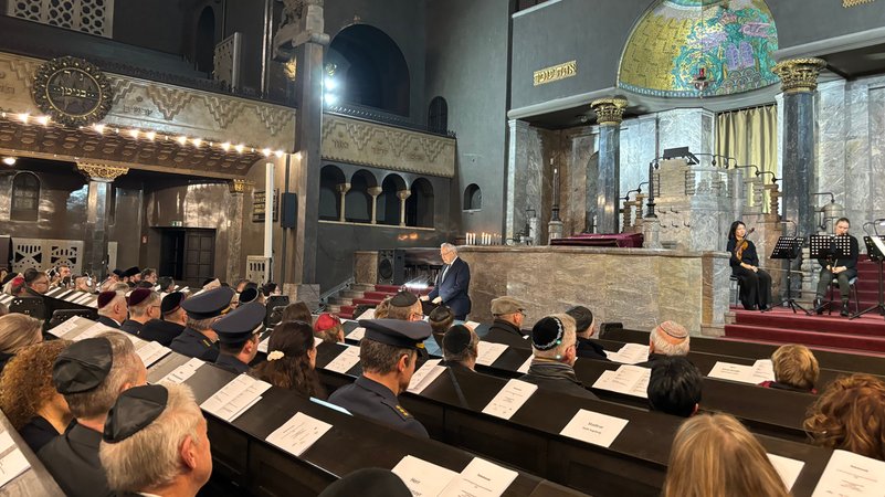 In der Augsburger Synagoge steht Bayerns Innenminister Joachim Herrmann am Rednerpult und gedenkt den Opfern der Reichspogromnacht. Vor ihm sind alle Plätze in der Synagoge belegt. | Bild: BR/Barbara Leinfelder In der Augsburger Synagoge steht Bayerns Innenminister Joachim Herrmann am Rednerpult und gedenkt den Opfern der Reichspogromnacht. Vor ihm sind alle Plätze in der Synagoge belegt.