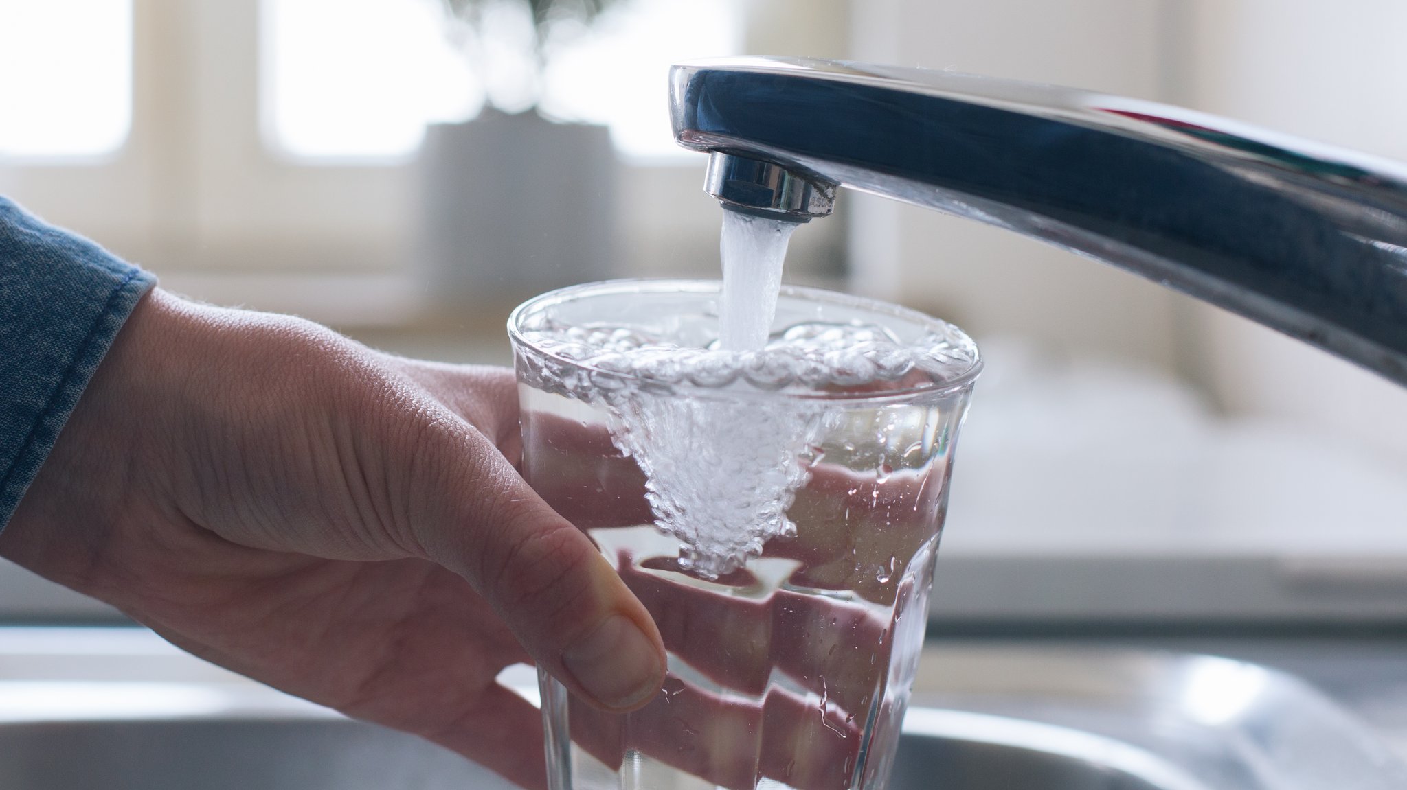 Wasser aus der Leitung fließt in ein Glas (Symbolbild)