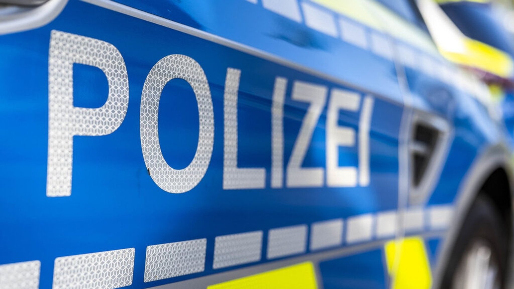 Schriftzug "Polizei" auf einem Streifenwagen