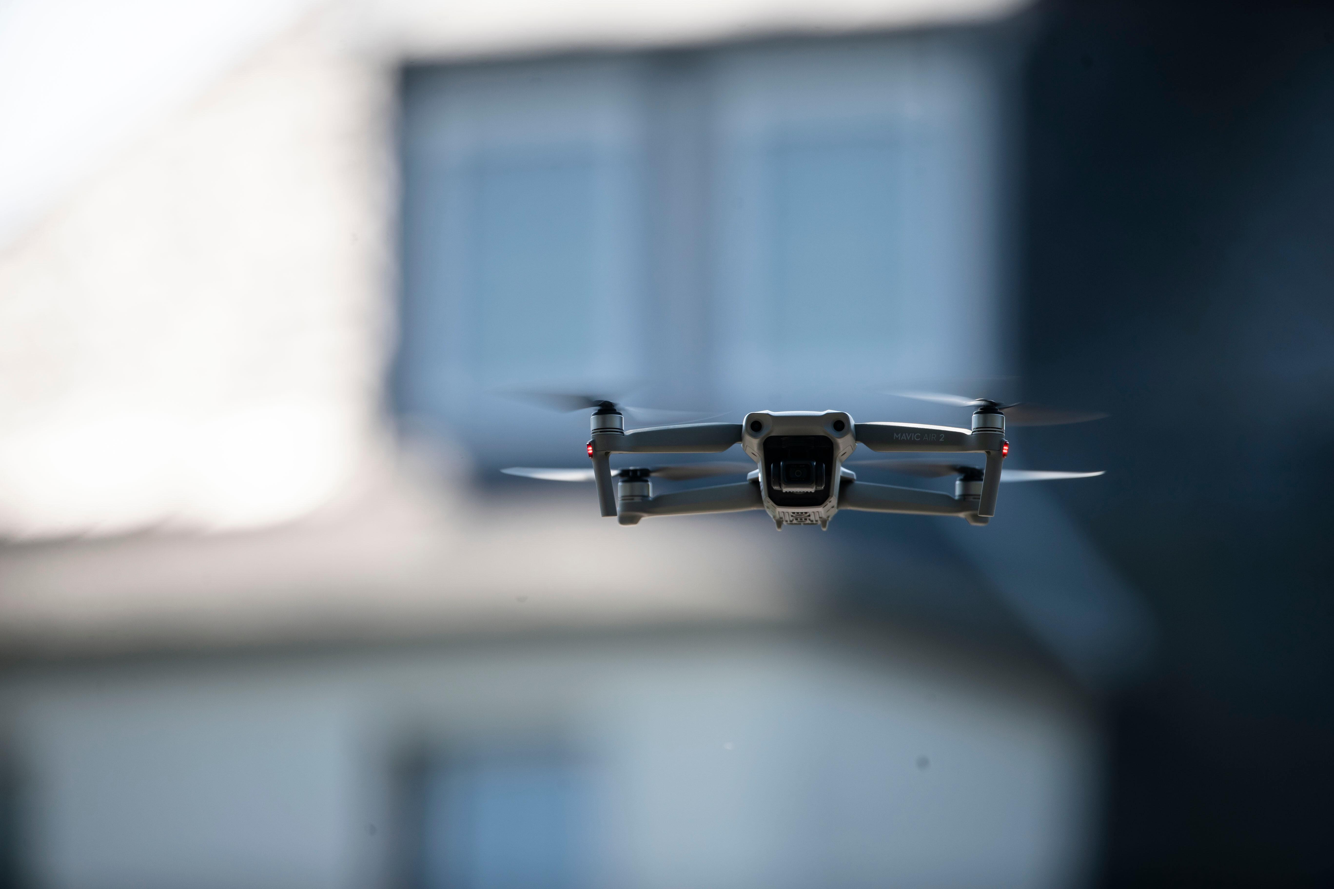 Drohne mit Kamera vor Wohnhaus