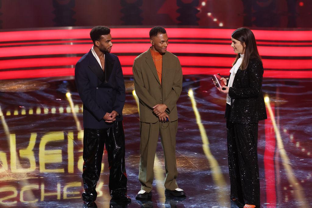 19.01.2024, Bayern, München: Verleihung Bayerischer Filmpreis: Für den Film «Girl You Know It's True» in dem sie das Pop-Duo "Milli Vanilli" spielen, erhalten Tijan Njie (l) und Elan Ben Ali (M) den Bayerischen Filmpreis und stehen mit Moderatorin Sandra Rieß auf der Bühne. Der Preis wird seit 1979 für hervorragende Leistungen verliehen. Foto: Karl-Josef Hildenbrand/dpa +++ dpa-Bildfunk +++