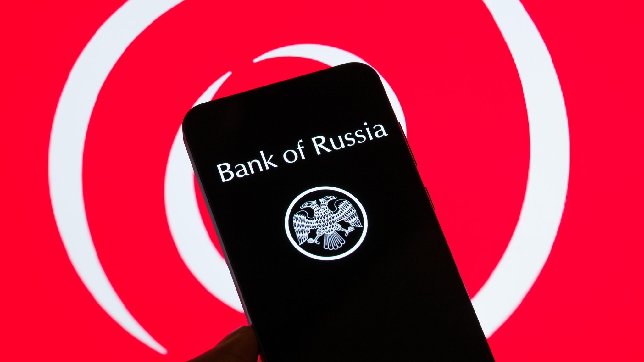 (Symbolbild) Ein Smartphone mit dem Logo "Bank of Russia", im Hintergrund ist groß das Logo von Euroclear zu sehen. | Bild: picture alliance / Sipa USA | Jonathan Raa (Symbolbild) Ein Smartphone mit dem Logo "Bank of Russia", im Hintergrund ist groß das Logo von Euroclear zu sehen.