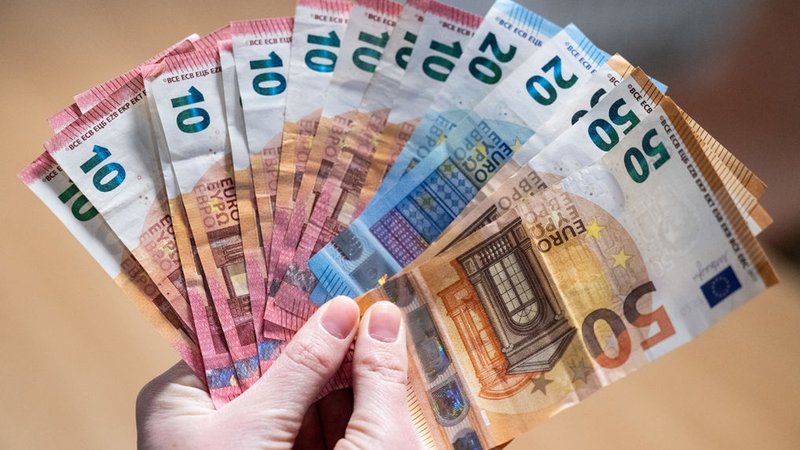 ILLUSTRATION - 24.11.2023, Berlin: Eine Person hält zahlreiche Euro-Banknoten in der Hand. (zu dpa: «EU-Parlament stimmt über neue Schuldenregeln ab») Foto: Hannes P Albert/dpa +++ dpa-Bildfunk +++