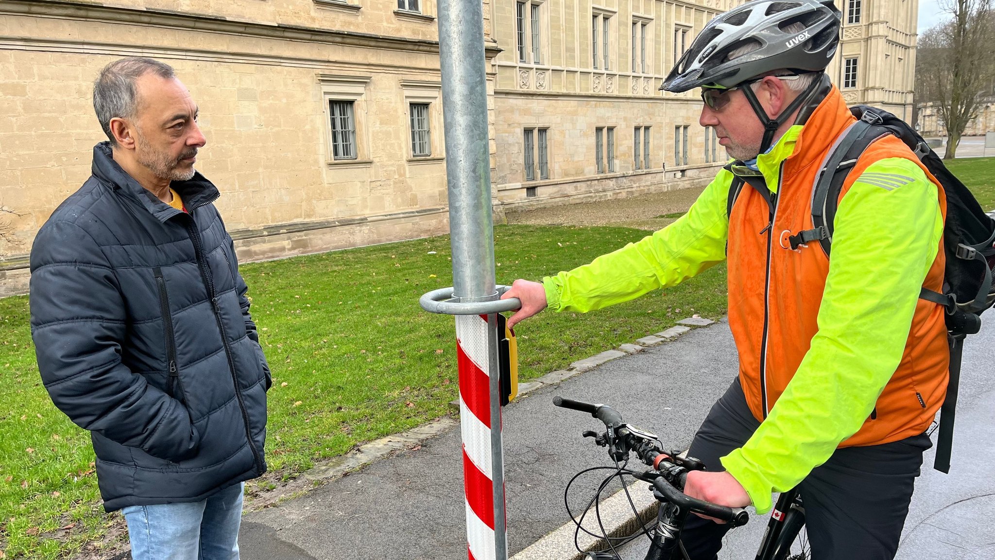 Coburgs Stadtsprecher Louay Yassin unterhält sich mit Klaus Brondke vom ADFC an einem Drückermast