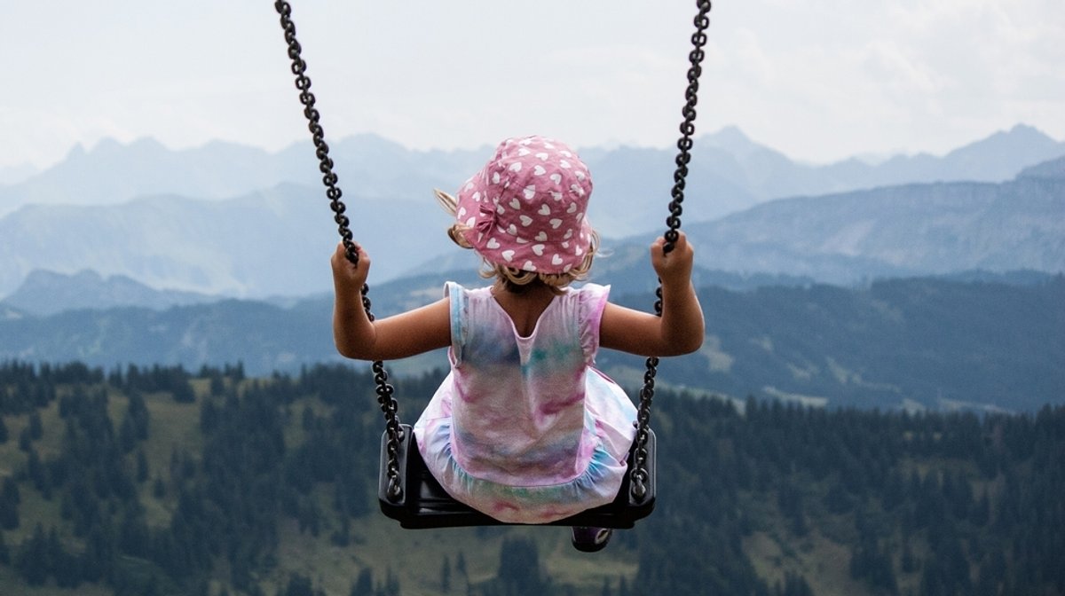 Ein Kind auf einer Schaukel am Hochgrat in den Allgäuer Bergen.
