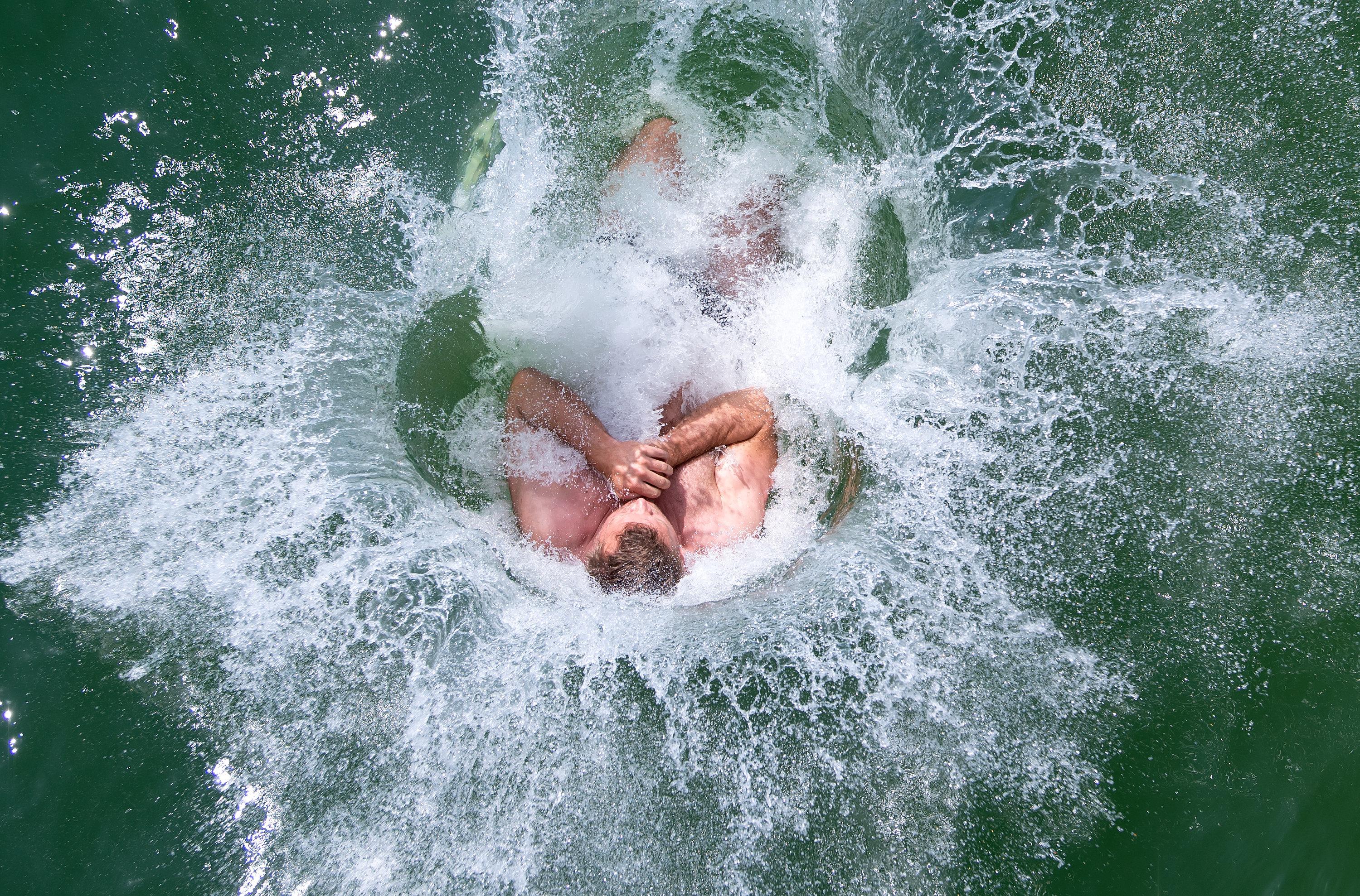 Ein Schwimmer kühlt sich durch einen Sprung in den Ammersee ab. | Bild:pa/dpa/Sven Hoppe