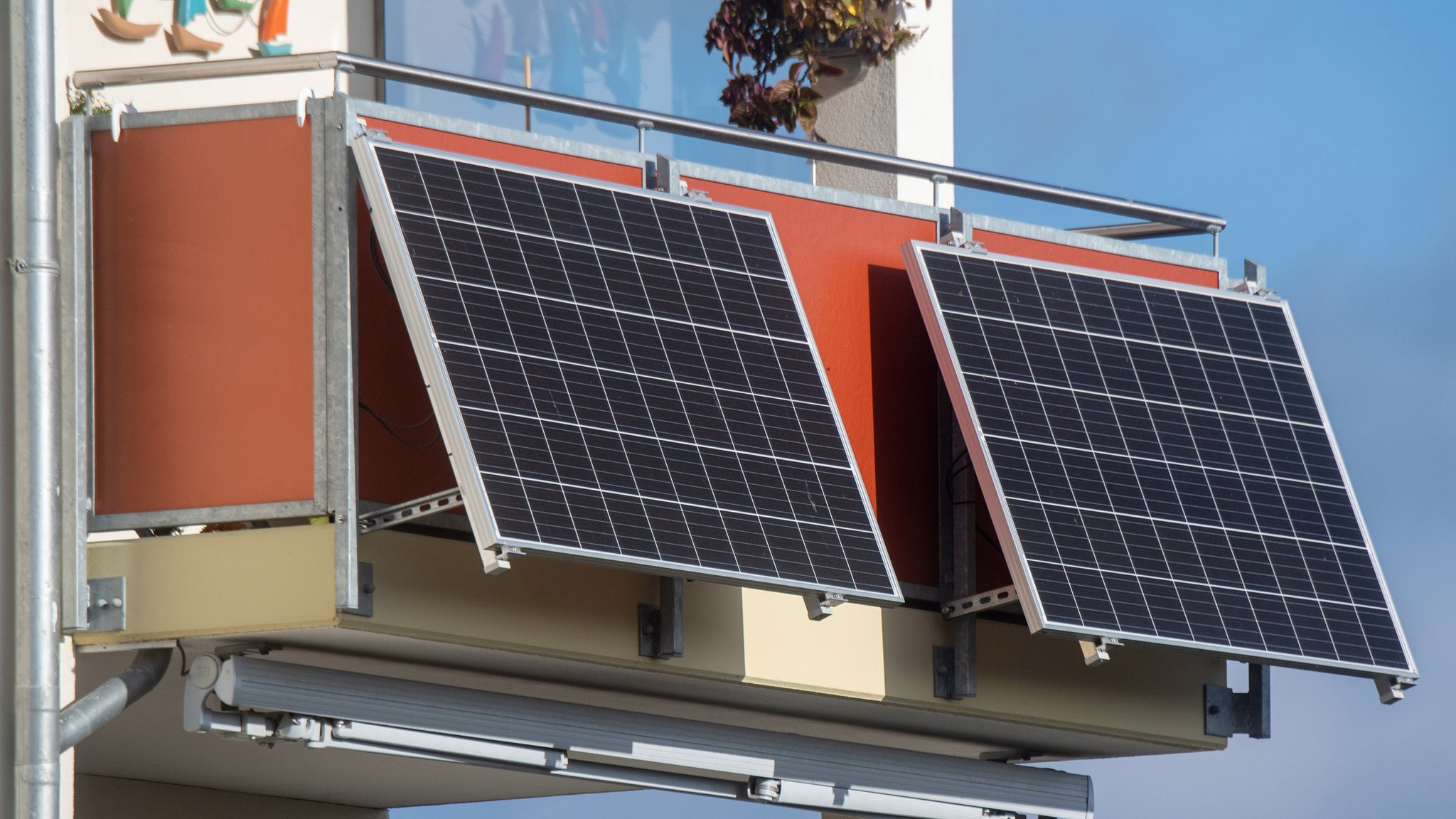 Solarmodule für ein sogenanntes Balkonkraftwerk hängen an einem Balkon. 