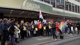 Menschen stehen mit Fahnen und Plakaten vor der Kaufhof Filiale in Würzburg | Bild:BR Fernsehen