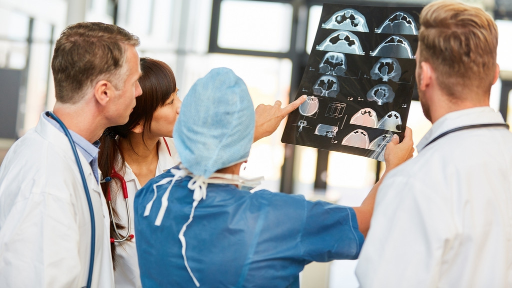 Ärzteteam bei Auswertung und Diskussion von MRT-Schnittbild in der Radiologie