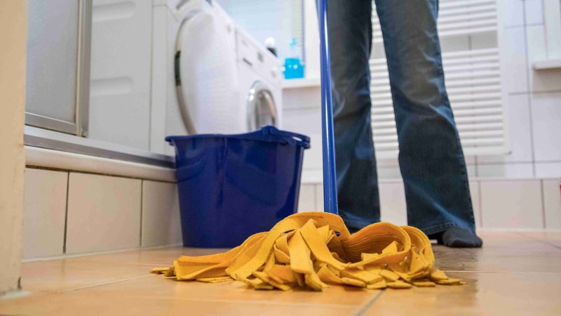 Frau wischt in einem Bad den Boden mit einem Wischmop | Bild: picture alliance / dpa Themendienst | Christin Klose Frau wischt in einem Bad den Boden mit einem Wischmop