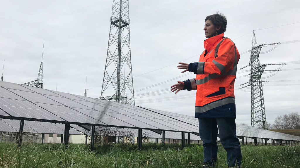 Sigrid del Rio vor Photovoltaikanlage auf dem Gelände des Wasserkraftwerks Meitingen