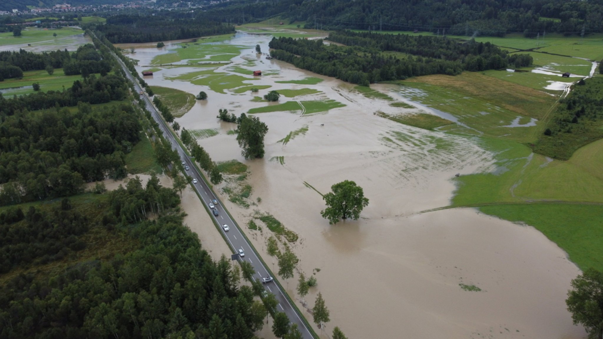 Eine Landstraße quert überschwemmte Wiesen.