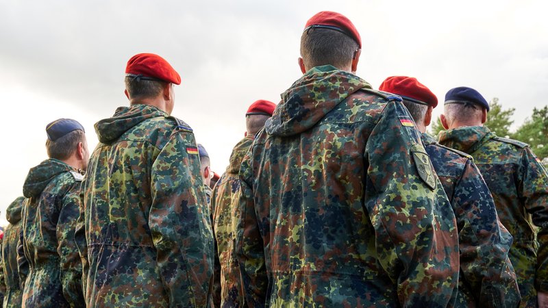 Soldaten der Bundeswehr stehen in Reih und Glied, gekleidet in Flecktarnuniformen und tragen rote sowie blaue Baretts. | Bild: picture alliance / CHROMORANGE | Michael Bihlmayer Soldaten der Bundeswehr stehen in Reih und Glied, gekleidet in Flecktarnuniformen und tragen rote sowie blaue Baretts.
