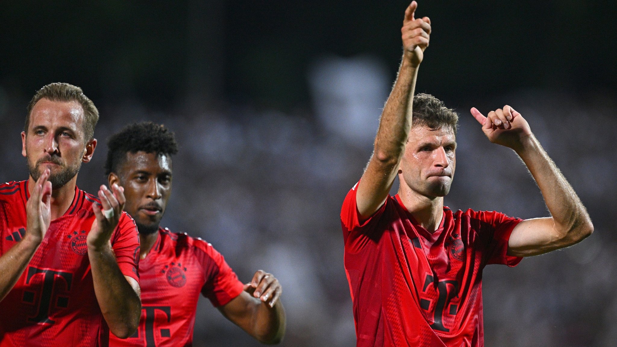 16.08.2024, Baden-Württemberg, Ulm: Fußball, DFB-Pokal, 1. Runde, SSV Ulm 1846 - Bayern München, Donaustadion: Münchens Thomas Müller (r), Münchens Kingsley Coman (M) und Münchens Harry Kane jubeln nach dem Spiel. WICHTIGER HINWEIS: Gemäß den Vorgaben der DFL Deutsche Fußball Liga bzw. des DFB Deutscher Fußball-Bund ist es untersagt, in dem Stadion und/oder vom Spiel angefertigte Fotoaufnahmen in Form von Sequenzbildern und/oder videoähnlichen Fotostrecken zu verwerten bzw. verwerten zu lassen. 